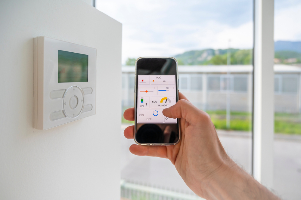 Hand,Holding,A,Mobile,Phone,Showing,An,Home,Automation,App