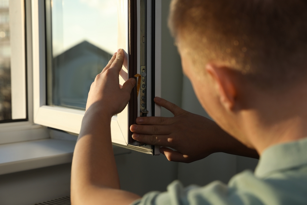 Construction,Worker,Putting,Sealing,Foam,Tape,On,Window,Indoors,,Closeup