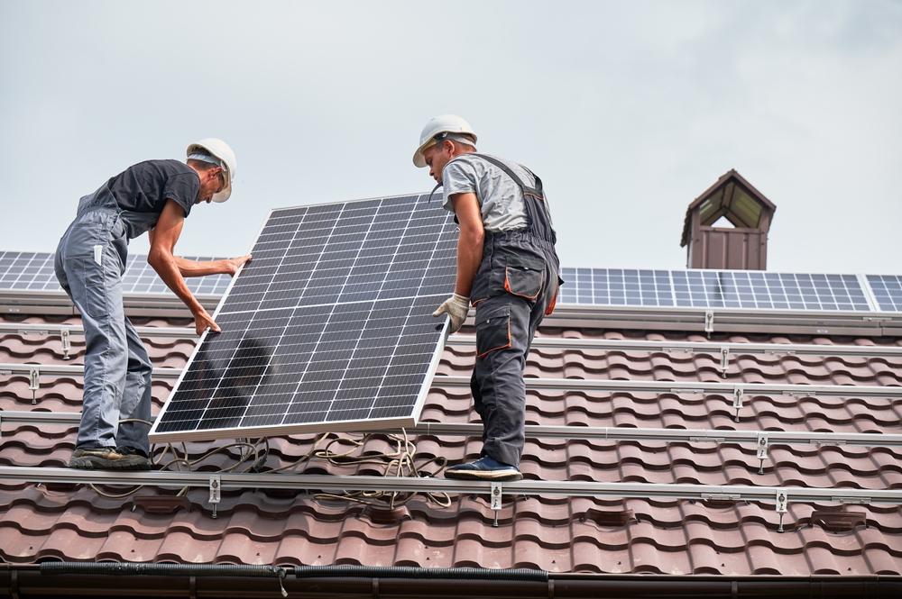 Men,Technicians,Lifting,Photovoltaic,Solar,Modul,On,Roof,Of,House.