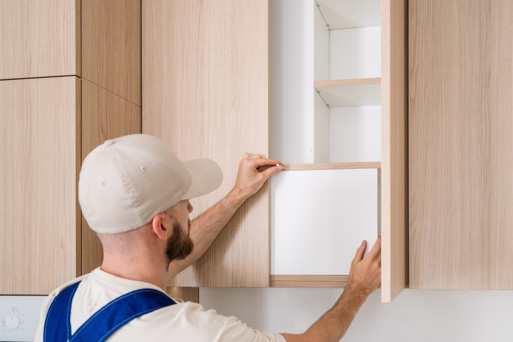 A,Professional,Handyman,Is,Working,On,Installing,New,Wooden,Cabinet